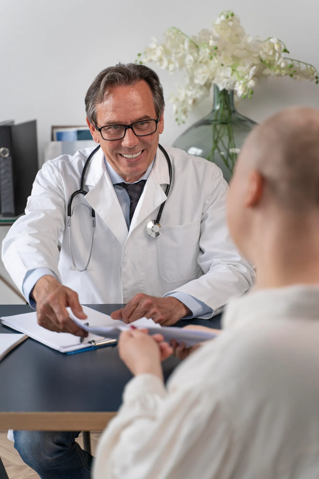Médico entregando documentos a una paciente durante una consulta