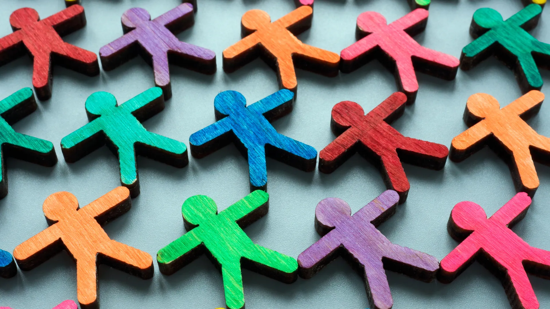 figuras humanas de madera pintadas de colores diversos en forma de mosaico