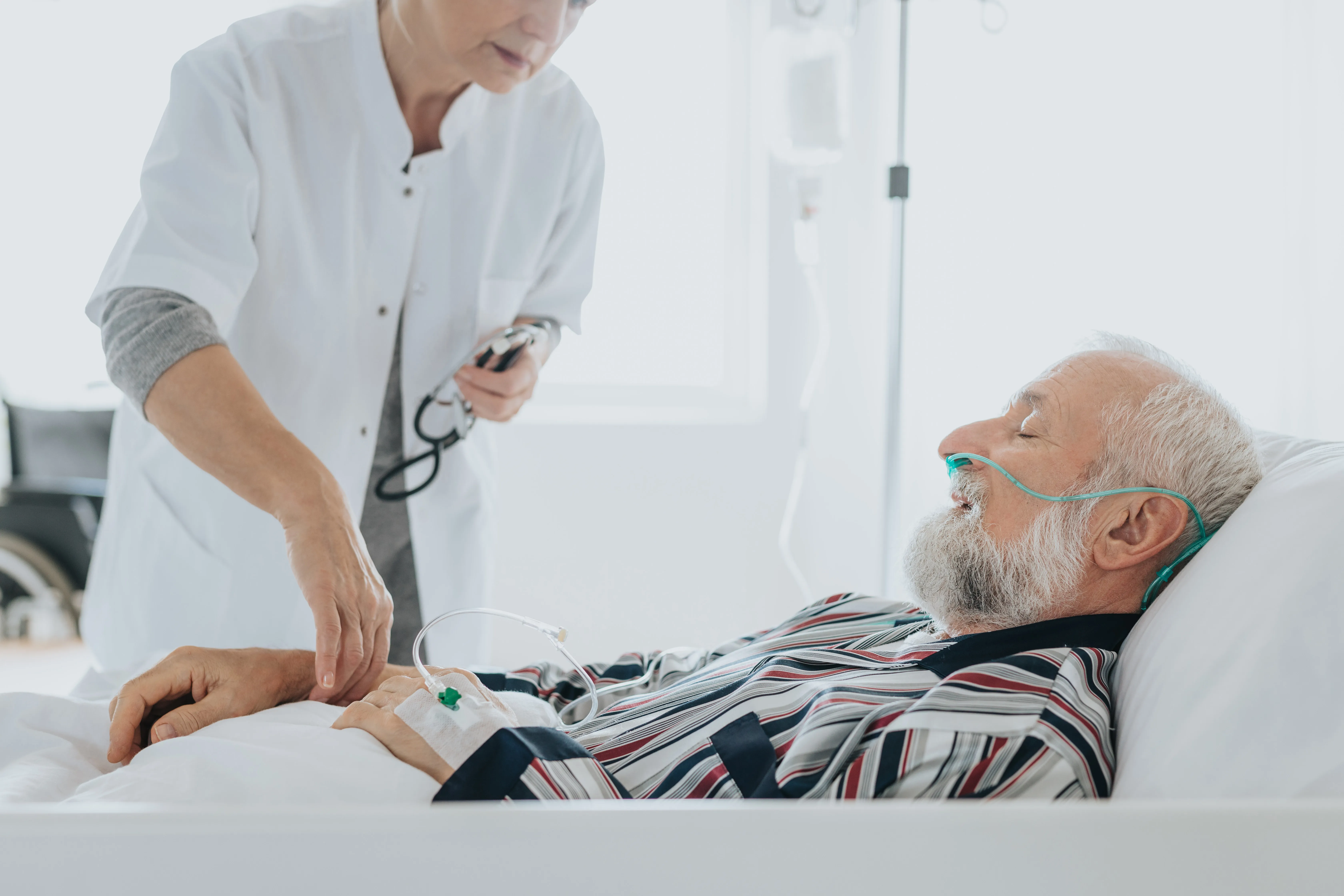un doctor atiende a un hombre mayor tumbado en una cama