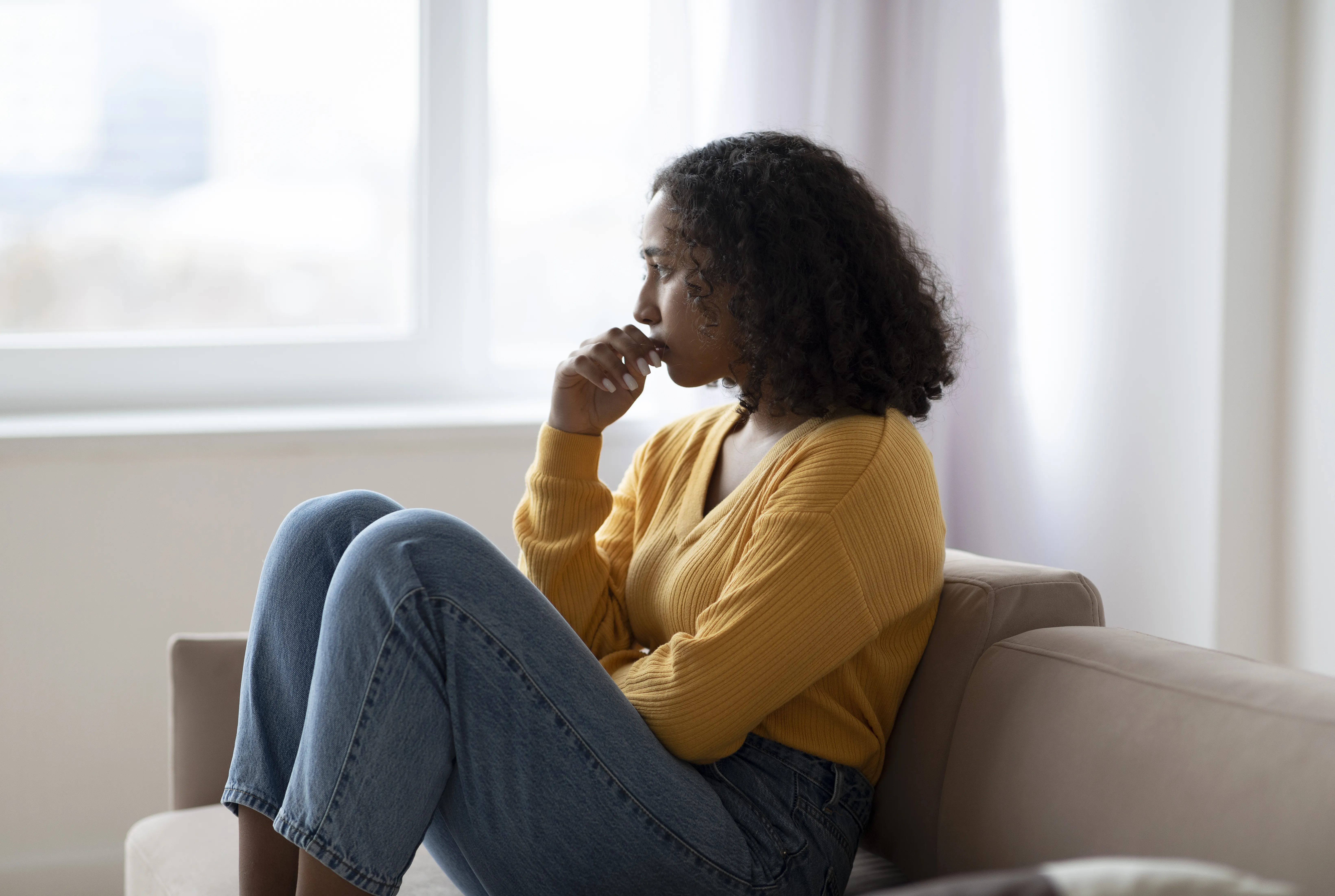 mujer pensativa en sofá
