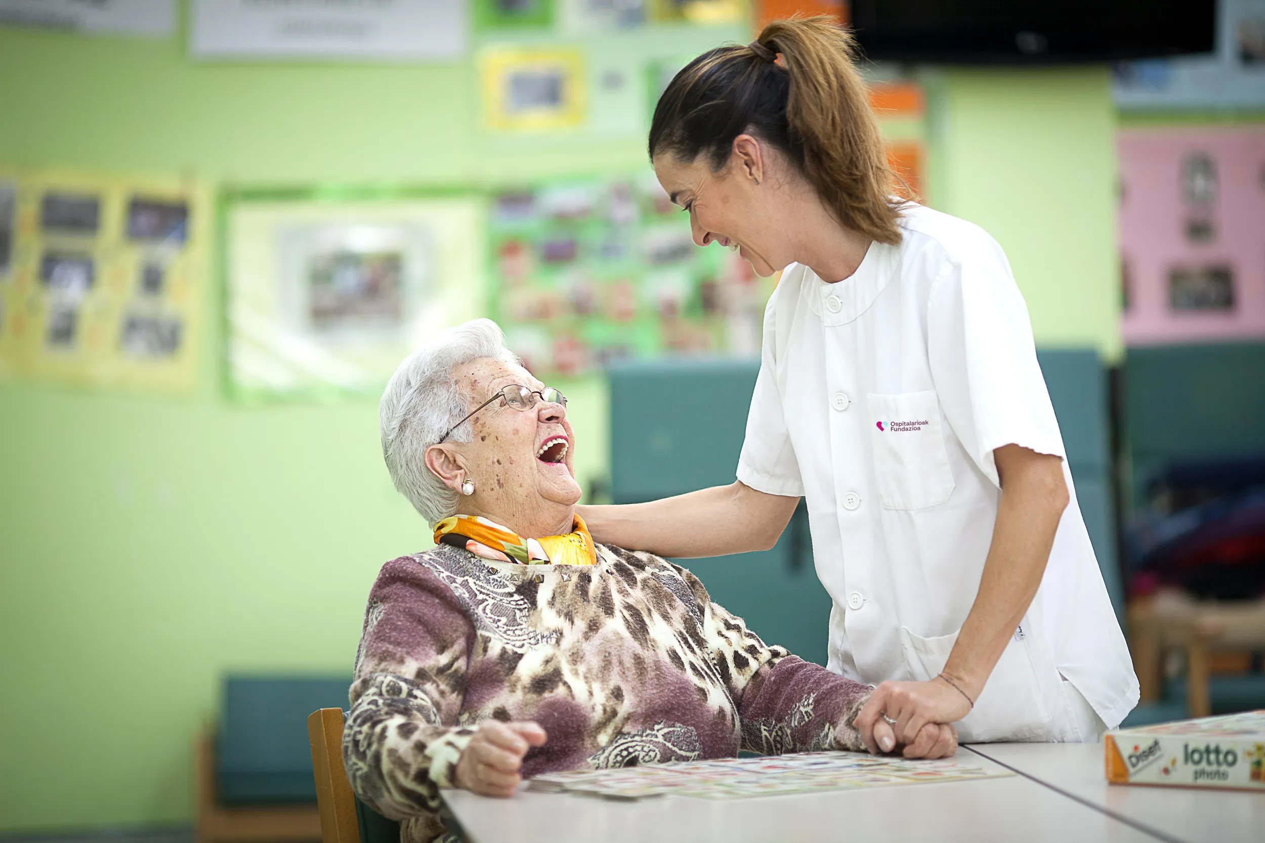 trabajadora de fundación hospitalarias con una mujer mayor que se ríe