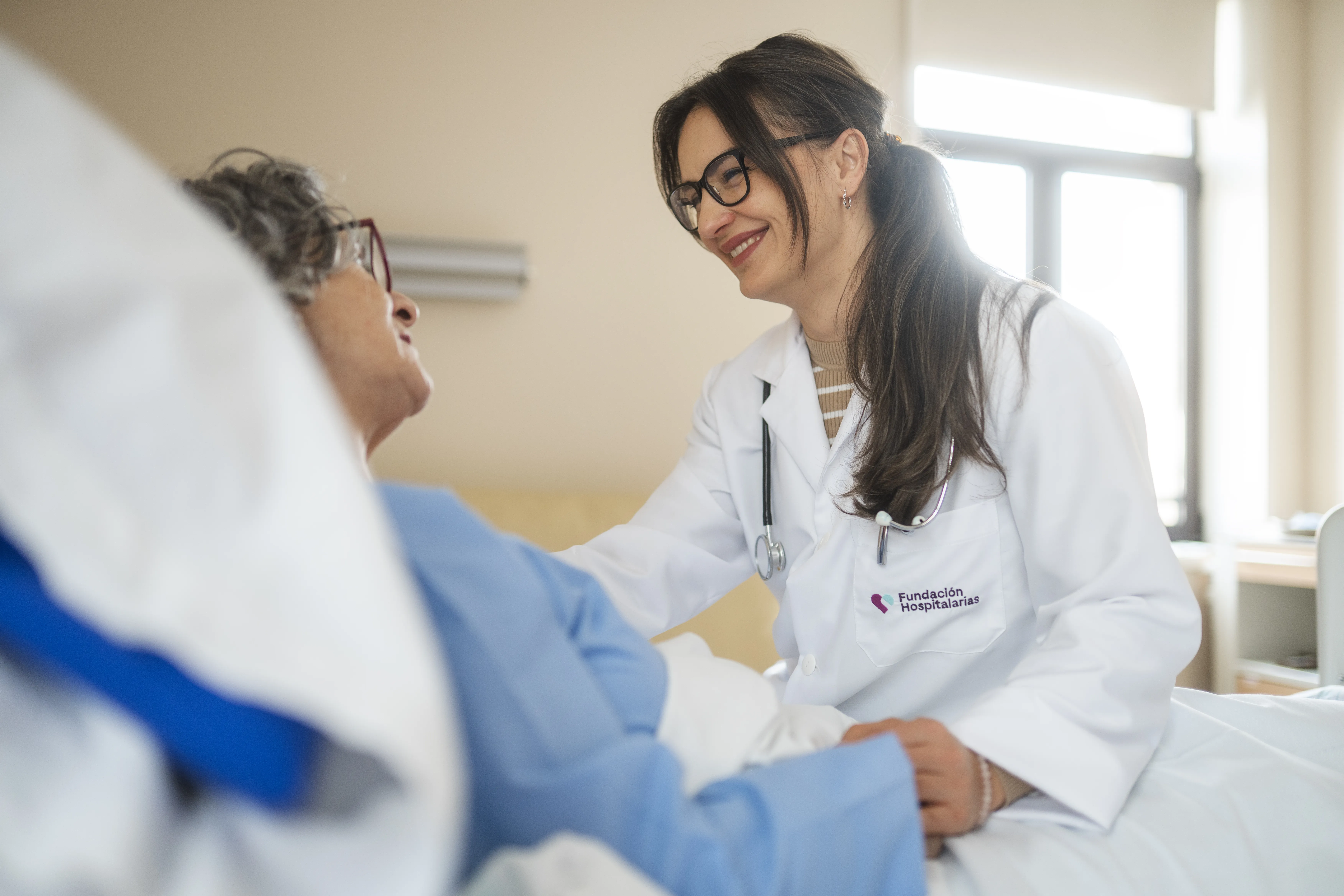 doctora de la Fundación Hospitalarias Madrid atiende a paciente en cama