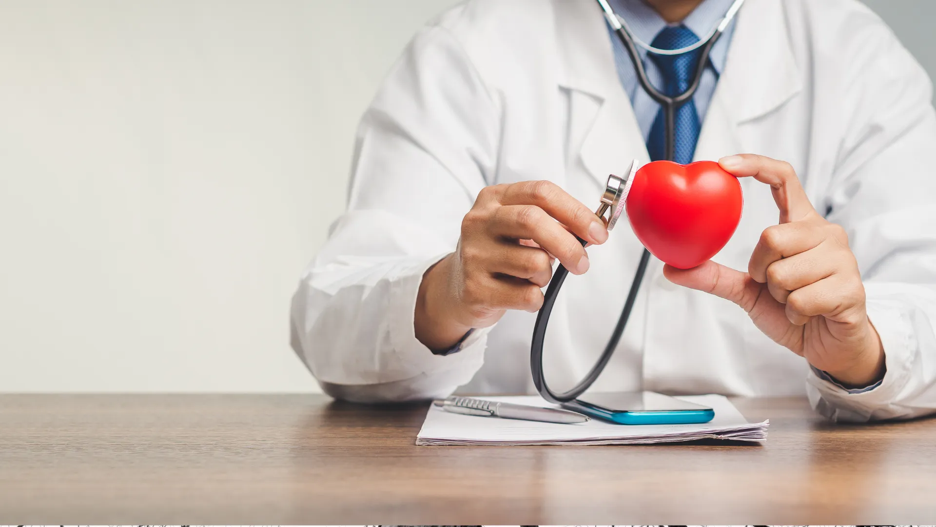 doctor sostiene un corazón de juguete