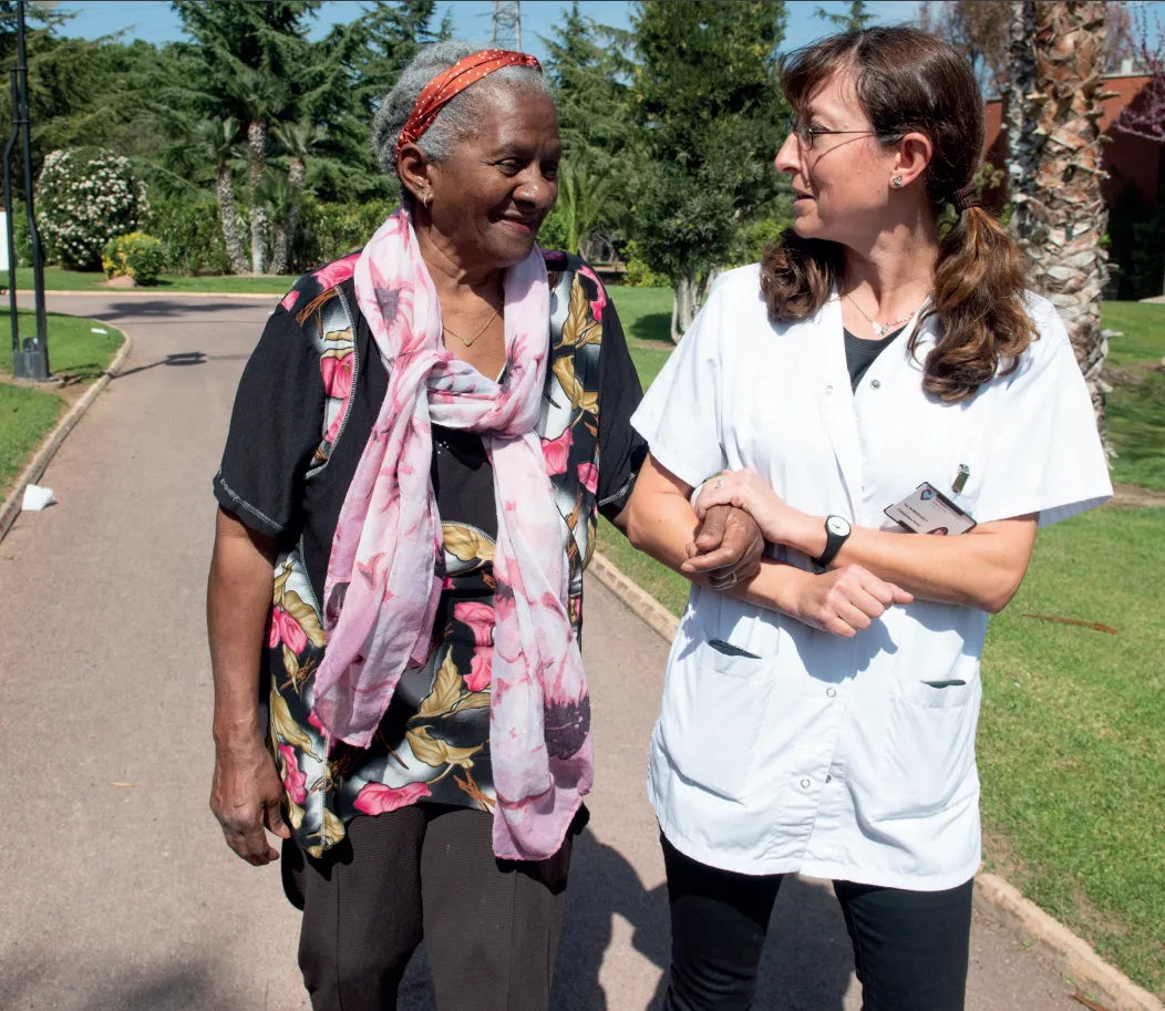 voluntaria de la fundación hospitalarias acompaña a una persona usuaria durante un paseo en el exterior
