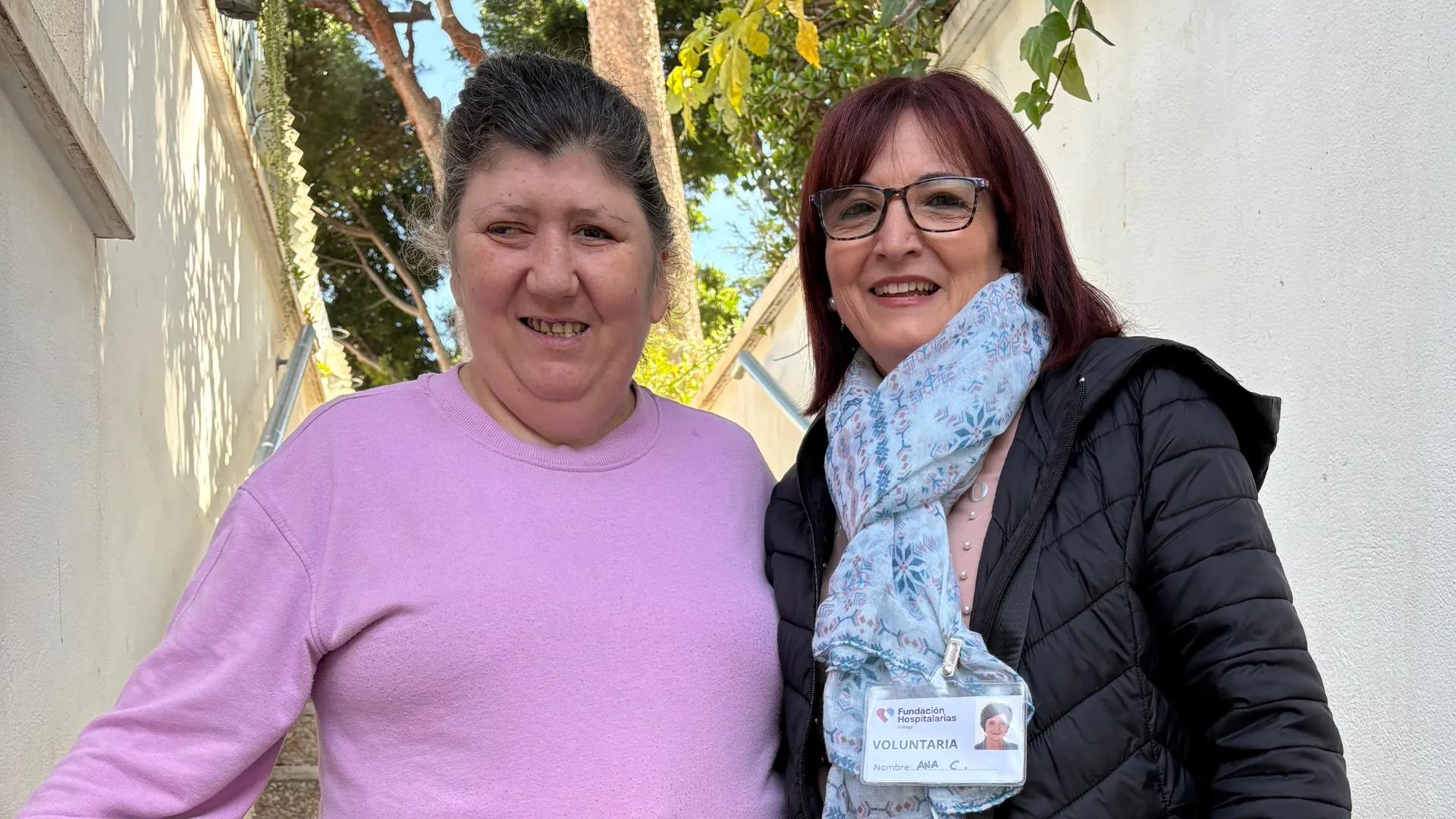 voluntaria de la Fundación Hospitalarias con una persona usuaria en el exterior