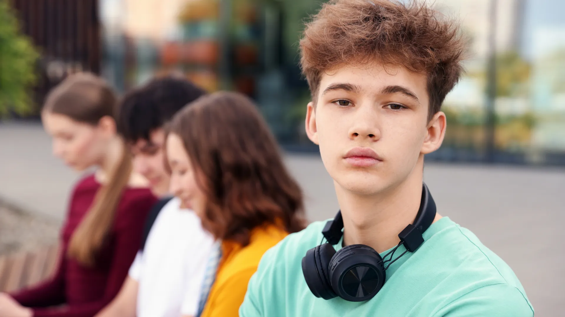 adolescente mira a cámara y detrás se ven más adolescentes