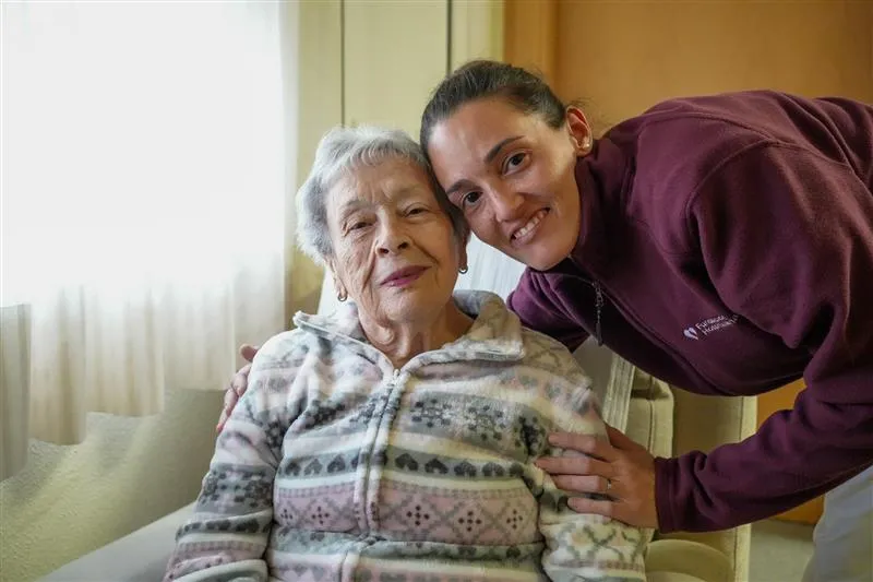 profesional de la fundacion hospitalarias valencia abraza a una mujer mayor