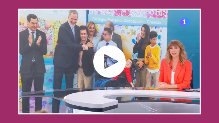 Imagen de la presentadora del telediario de TVE con la foto de SM el Rey de fondo durante la visita al centro de educación especial purísima concepción de hermanas hospitalarias en granada